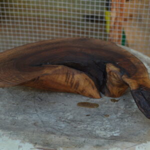 Side view of a live edge reclaimed California walnut serving board finished with food-safe mineral oil