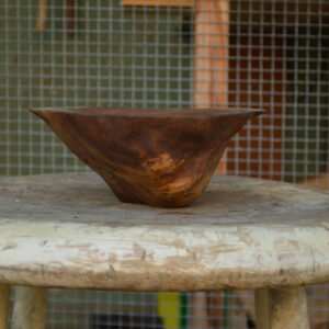 Side view of a live-edge shallow decorative bowl carved from reclaimed Bay Area walnut burl