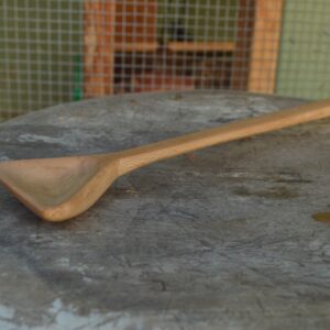 A hand-carved, triangular sycamore cooking spoon hand carved and finished with food-safe oil.